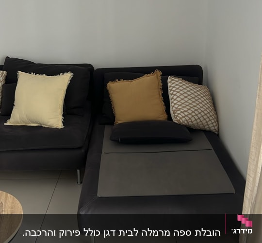 ספה אפורה עם כריות צבעוניות על רצפה בהירה